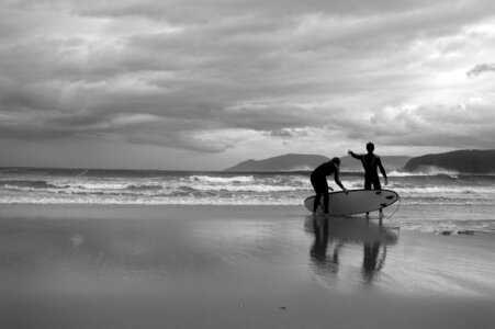 Happy surfers couple running with surf boards on the beach photo