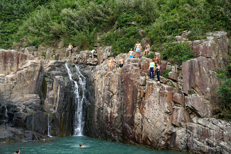 People swimming under the waterfall photo