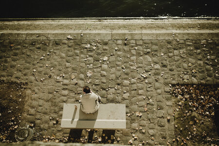 Man Sitting on a Bench at the River Bank of Seine photo