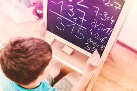 School kid drawing on blackboard at home. Education. photo