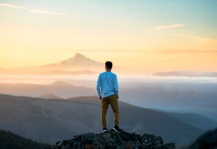 Man Standing on a Peak and Admire the Views photo