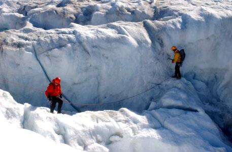A group of alpine hikers climbing along a big crevasse photo
