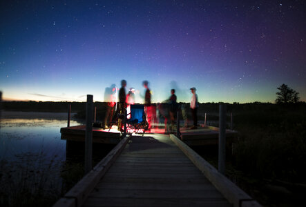 Group of Friends on a Pier by the Lake at Night photo