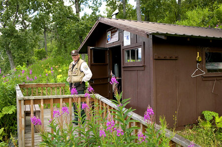 Service employee in front of Kodiak National Wildlife Refuge recreation cabin located at Uganik Lake photo