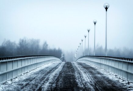 Bridge city landscape in foggy snowy winter day photo