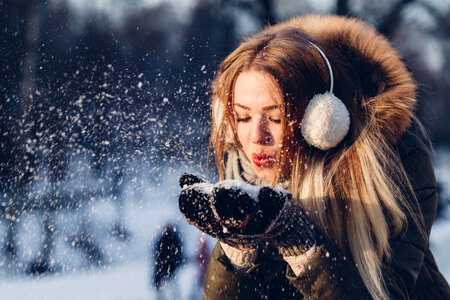 Young Woman Blowing Snow, Magic Snowfall Effect photo