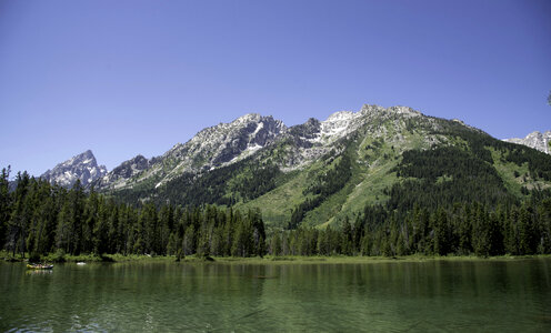 Mountains in the distance across the green lake water photo