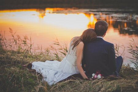 Wedding Couple on Grass at Sunset photo