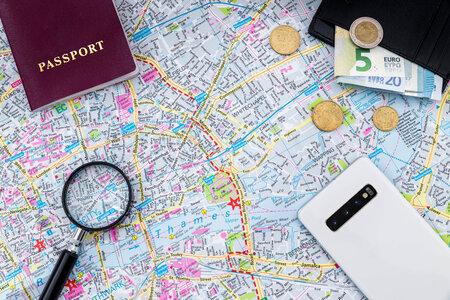 Magnifier on the map with passport, wallet with the money and smartphone photo