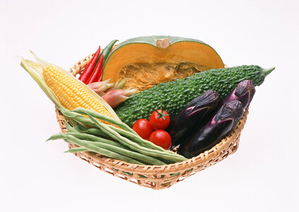 Indian bitter melons and vegetables and wicker basket photo