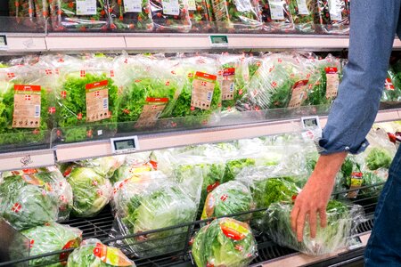 Woman picking lettuce in a grocery store photo