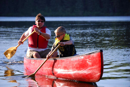 Man and boy paddle a canoe-1 photo