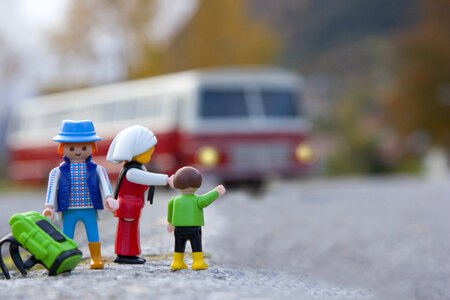 Miniature Family Traveling by Bus with Backpack, Macro Photography. photo