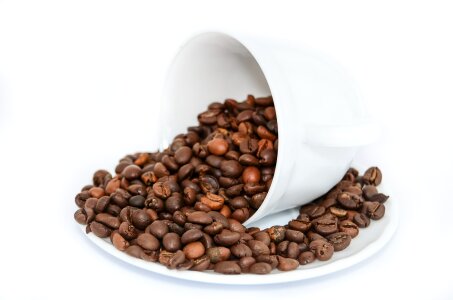 Coffee beans in coffee cup isolated on white photo