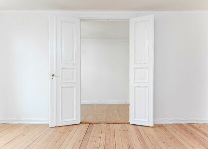 White Door in Empty Apartment Room with Wooden Floor photo