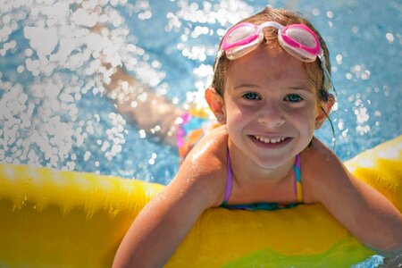 Children sitting on inflatable ring in swimming pool. photo