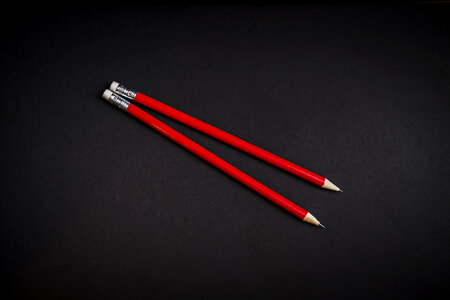 Two Red Pencils on Black Background photo