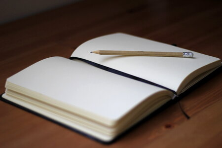 Blank Notebook with Pencil on Desk Background photo