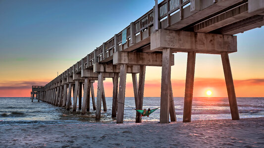 Hanging a Hammock above the waves off a bridge photo