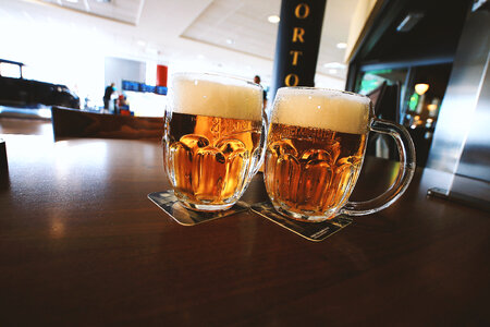 Two glasses of beer on a wooden table photo
