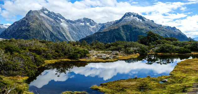 Milford Sound with mountains and reflective lake and clouds photo