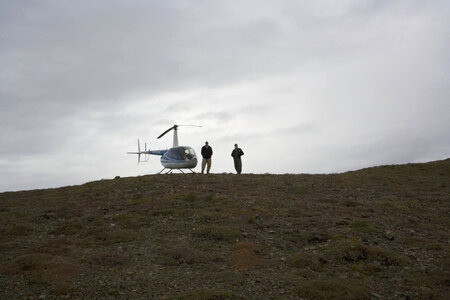 U.S. Fish and Wildlife Service employees stand by grounded helicopter