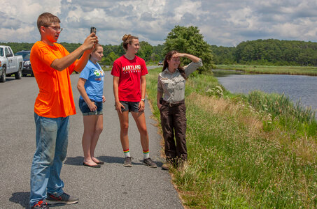 FWS staff with students taking cell phone pictures at wetland-1
