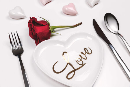 1 Fork, knife and spoon with red rose on white table. Love concept photo