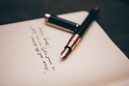 An Opened Pen with Some Handwritten Text photo