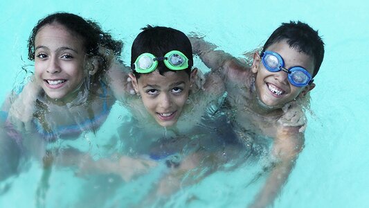 Two Boys and a Girl Playing In the Swimming Pool photo