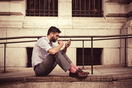 Man Sitting on the Floor in Front of a Building photo