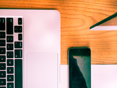 Laptop and Phone on Wooden Desk photo