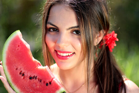 Pretty young woman eating watermelon photo
