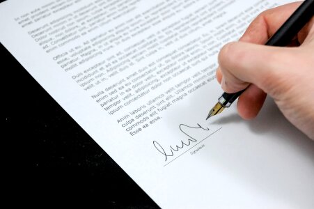 Man signing business document, application photo