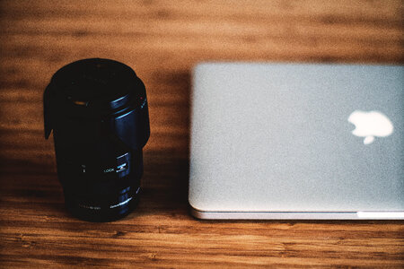 Canera Lens & MacBook Laptop on Wooden Desk photo