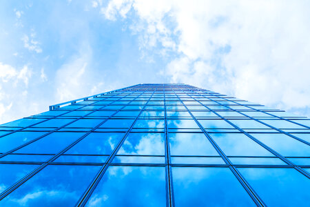 Sky with clouds in the reflection in windows of modern office building photo
