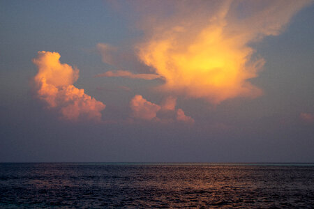 Two Orange Clouds Over the Sea at Sunset