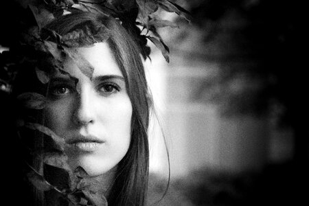 Black and White Portrait of a Beautiful Young Woman Hidden in the Leaves photo