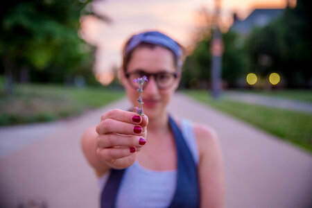 Girl with Red Nail Polish Holding a Single Flower photo