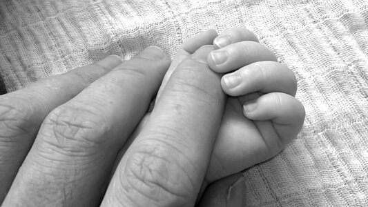 Hand the sleeping baby in the hand of mother close-up