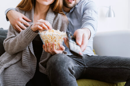 Happy young couple relaxing and watching TV at home photo