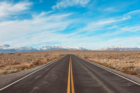 Empty Asphalt Road and Cloudy Mountains in Background photo
