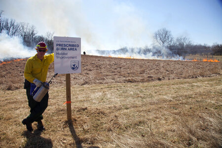 Firefighter stands beside sign