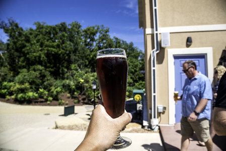 Hand holding a pint of Cherry Berry at New Glarus Brewery photo