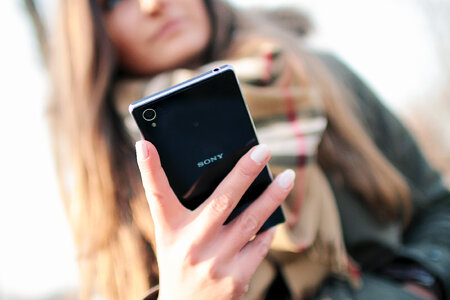 Back black luxury smartphone in hand modern woman photo