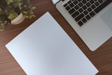 Work table with paper and laptop on the wooden table photo