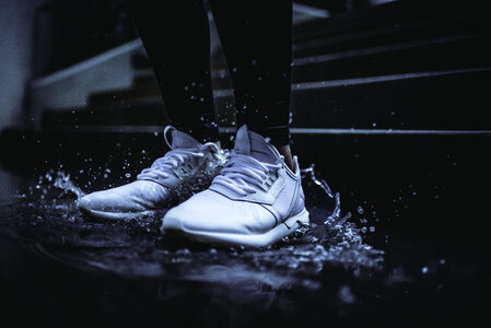 White Sneakers Splashing in Puddle photo