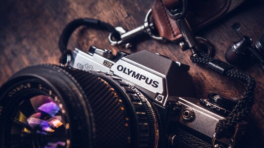 Old SLR Olympus Camera on Wooden Background photo