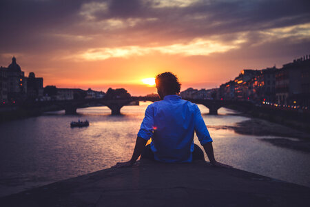 Man Enjoying View of Ponte Santa Trinita in Florence at Sunset photo