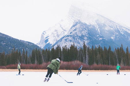 Kids Playing Outdoor Hockey at the Foot of the Mountain photo